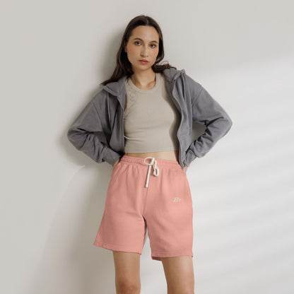 Woman styling a grey zip-up hoodie with B+ Official pink lounge shorts.
